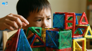 Bé trai tập trung tư duy lắp ghép các khối nam châm màu sắc tại lớp học KidsEdu STEM.